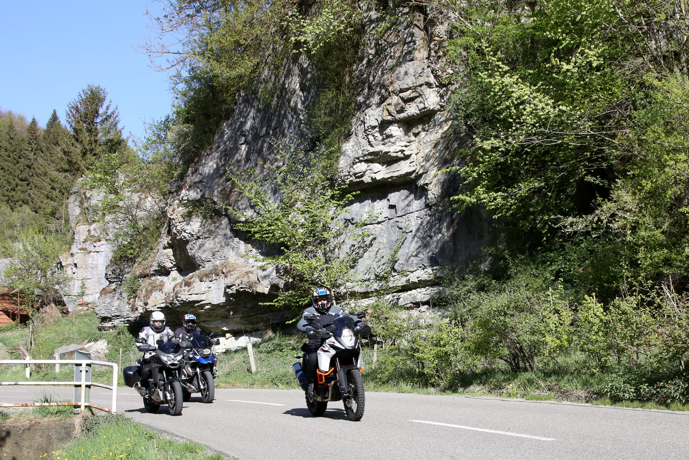 Motorräder auf der Straße unter einer typischen Kalkfelswand der Alb